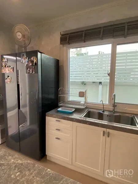 บ้าน ขายในBang Sao Thong, Samut Prakan - มุมครัวมีอ่างล้างจานคู่ใต้วงกบหน้าต่างและตู้เย็นขนาดใหญ่แบบสองประตู