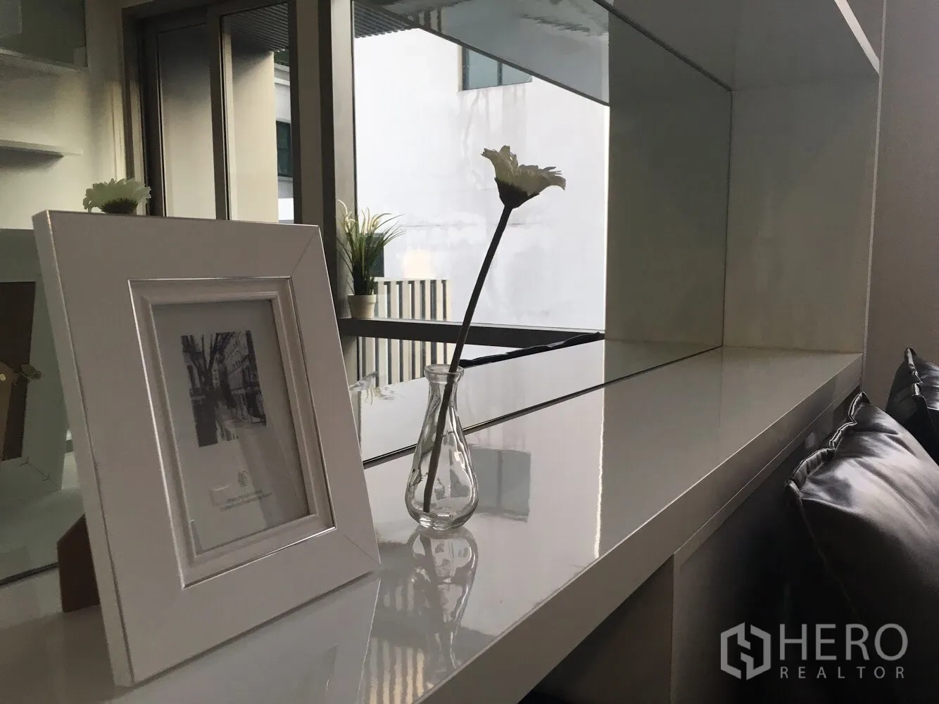 คอนโด ให้เช่าในKhlong Toei, Bangkok - ชั้นวางกระจกพร้อมกรอบรูปและแจกันดอกไม้ข้างหน้าต่าง