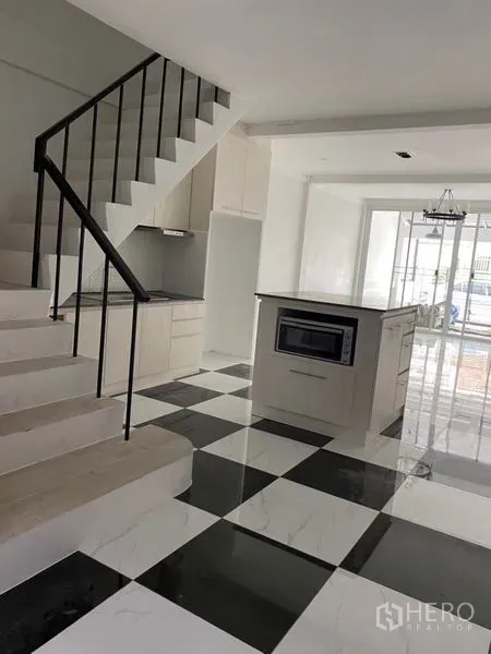 ทาวน์เฮาส์ ให้เช่าหรือขายในKhlong Toei, Bangkok - ครัวสมัยใหม่มีไอส์แลนด์ข้างบันได ประตูกระจกเชื่อมสู่ลานพักผ่อน