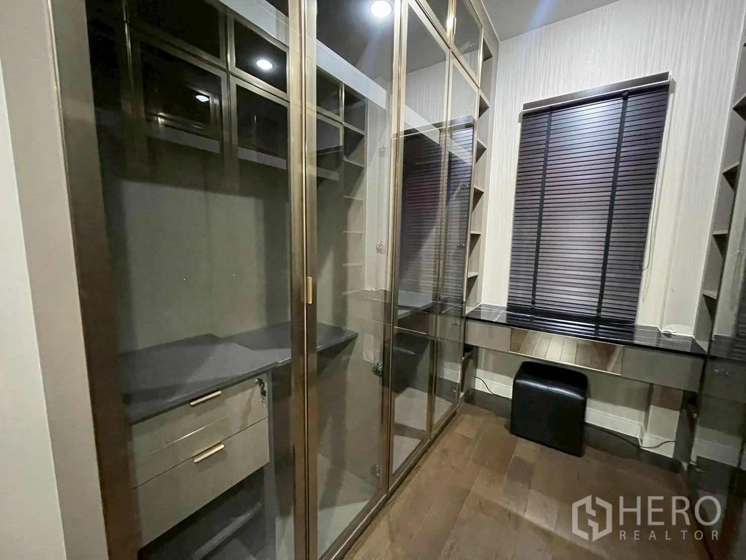 Detached House for rent in Bang Kapi, Bangkok - Walk-in closet with glass-front wardrobes and a dressing table.