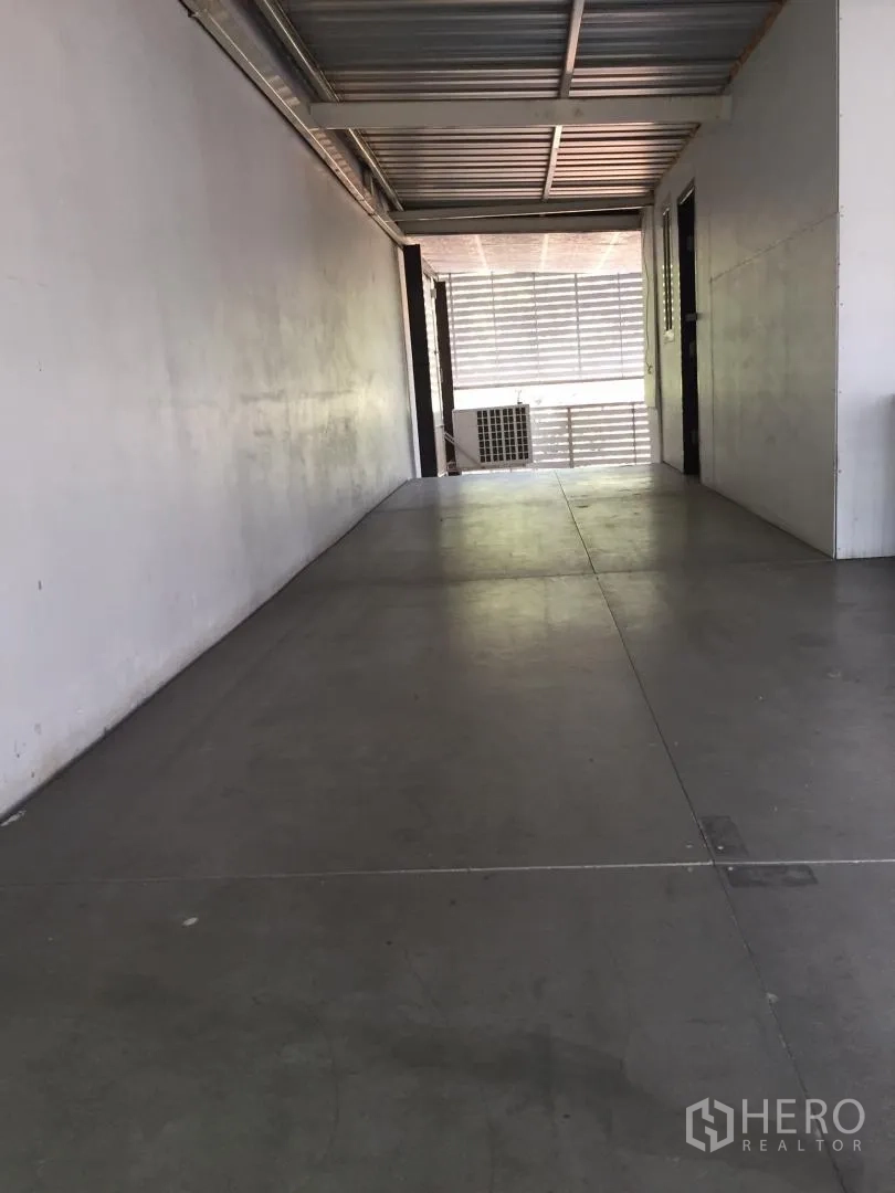 Home Office for rent or sale in Bang Khun Thian, Bangkok - Long internal corridor with metal roof and smooth concrete flooring.