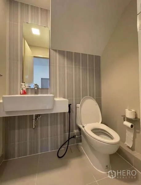 ทาวน์เฮาส์ ให้เช่าในPrawet, Bangkok - ห้องน้ำสมัยใหม่พร้อมอ่างล้างหน้า กระจก และโถสุขภัณฑ์พร้อมสายฉีด