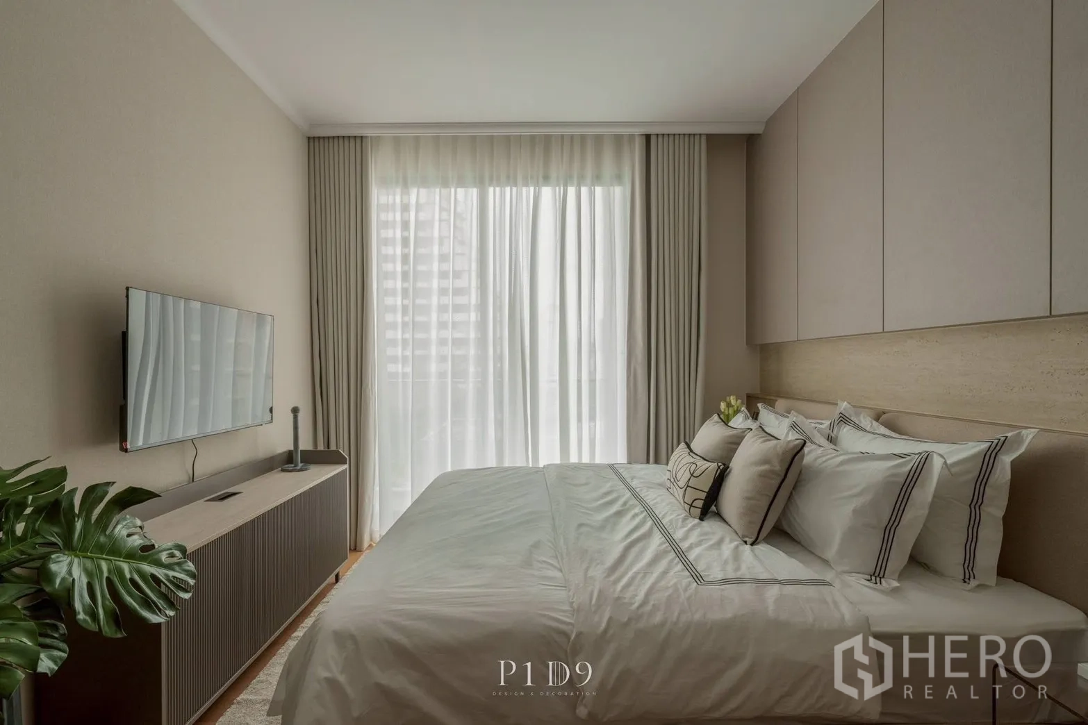 Condominium for rent in Watthana, Bangkok - Bedroom with a large bed, TV console, and floor-to-ceiling curtains.