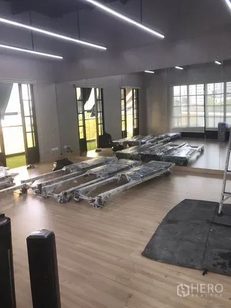 零售空间 出租在Watthana, Bangkok - 明亮的零售工作室，木质地板、镜面墙、大窗户与线性LED照明