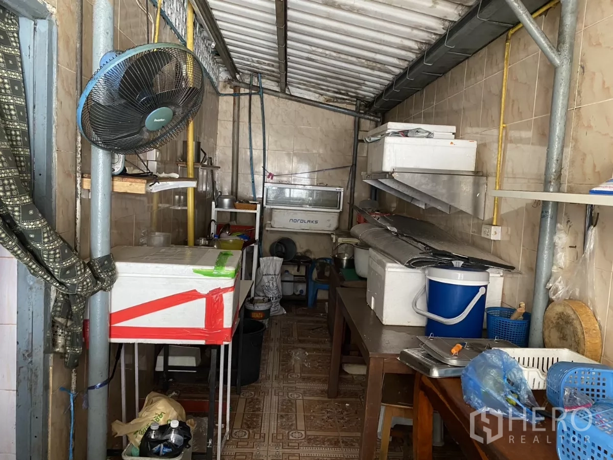 店屋 出租在Khlong Toei, Bangkok - 狭长备餐厨房，瓷砖墙、置物架与通风扇。