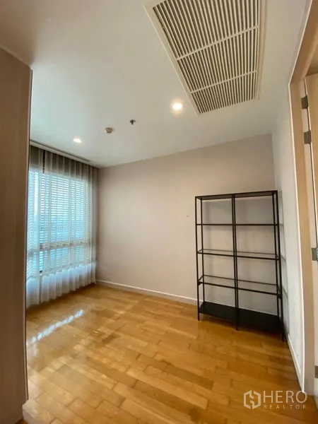 Condominium for rent or sale in Yan Nawa, Bangkok - Second bedroom or study with window blinds, open metal shelving and wood floors.