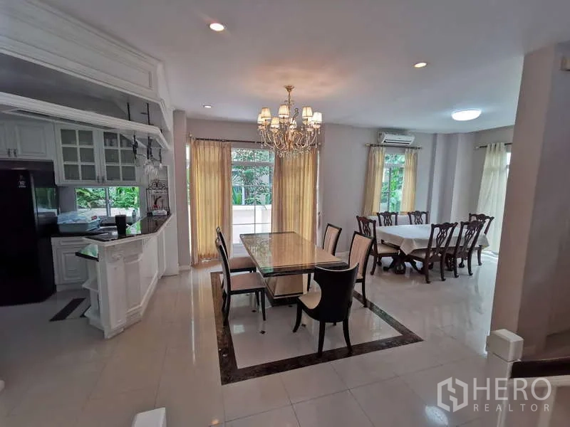 บ้าน ให้เช่า - ห้องรับประทานอาหารกว้าง โคมระย้า โต๊ะหินอ่อน และชุดโต๊ะอาหารอีกชุด เชื่อมแพนทรี่และระเบียง