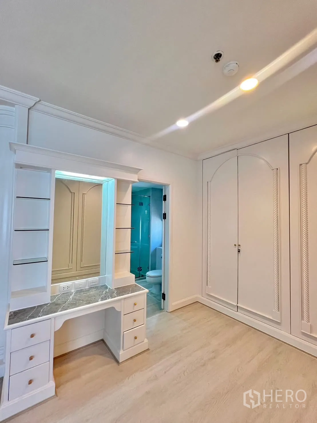 Condominium for rent in Khlong Toei, Bangkok - Dressing area with vanity desk and fitted wardrobes leading to an ensuite.
