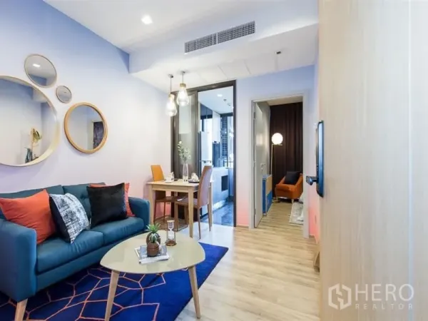 คอนโด ให้เช่าในChatuchak, Bangkok - ห้องนั่งเล่นคอนโดจตุจักรสว่าง โปร่ง โซฟาสีเขียวอมฟ้า กระจกกลม ชุดทานอาหาร และพื้นไม้