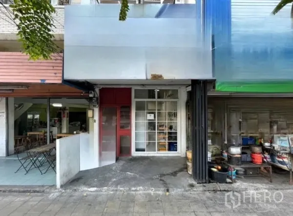 店屋 出售在Suan Luang, Bangkok - Suan Luang店屋的街道立面，正面玻璃与红色侧门。