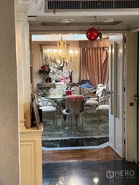 คอนโด ขายในKhlong Toei, Bangkok - ห้องรับประทานอาหารโต๊ะกระจกยาว เก้าอี้โทนทอง และโคมระย้า มองผ่านประตู