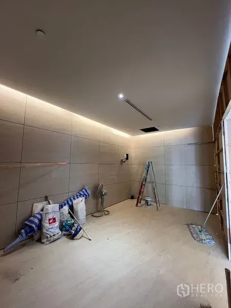 零售空间 出租在Pathum Wan, Bangkok - 小型店铺内部，瓷砖墙面与射灯，摆放工具，方正布局。