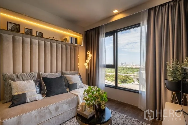 公寓 出售在Chatuchak, Bangkok - 客厅设大窗与城市及公园景观，沙发温馨舒适