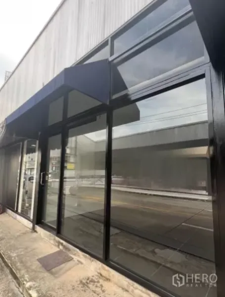 Retail Space for rent in Khlong Toei, Bangkok - Black-framed shopfront windows with a blue awning facing the road and offering strong visibility.