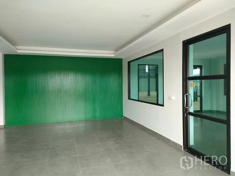工厂 出租在Ban Phaeo, Samut Sakhon - 办公大堂，绿色特色墙与通往车间的玻璃门。