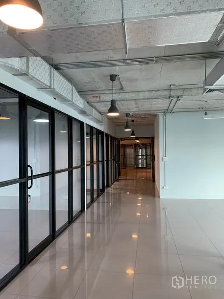 办公空间 出租在Phaya Thai, Bangkok - 走廊宽敞，工业风吊灯与整排推拉玻璃门相伴。