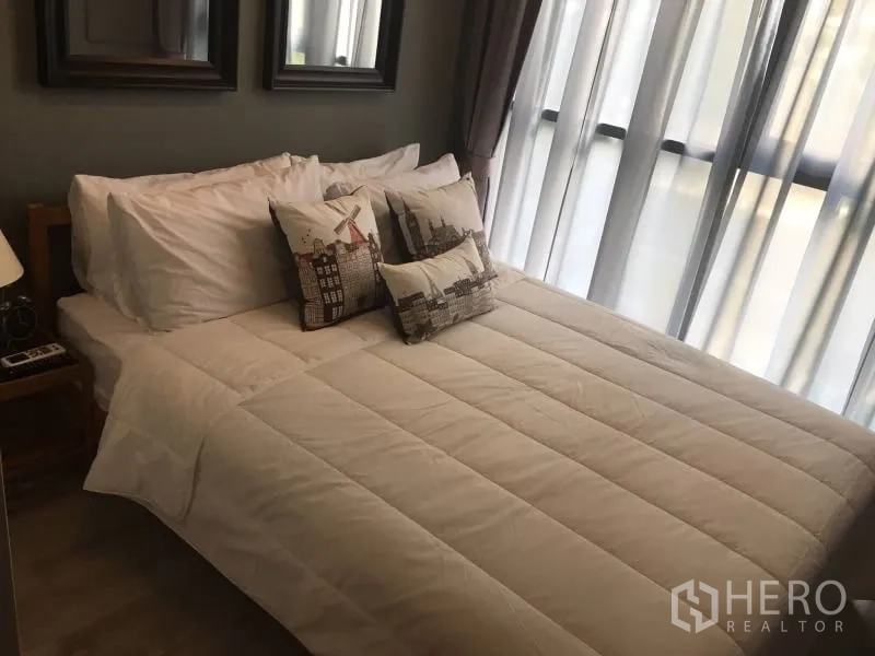 Condominium for rent in Phra Khanong, Bangkok - Bright bedroom with double bed, white bedding, and sheer curtains