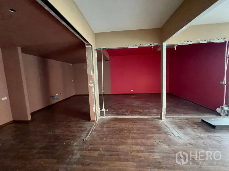 พื้นที่ขายปลีก ให้เช่าในPhaya Thai, Bangkok - ห้องกั้นเป็นสัดส่วน พื้นไม้โทนเข้ม และผนังสีแดงสำหรับปรับผังได้ยืดหยุ่น