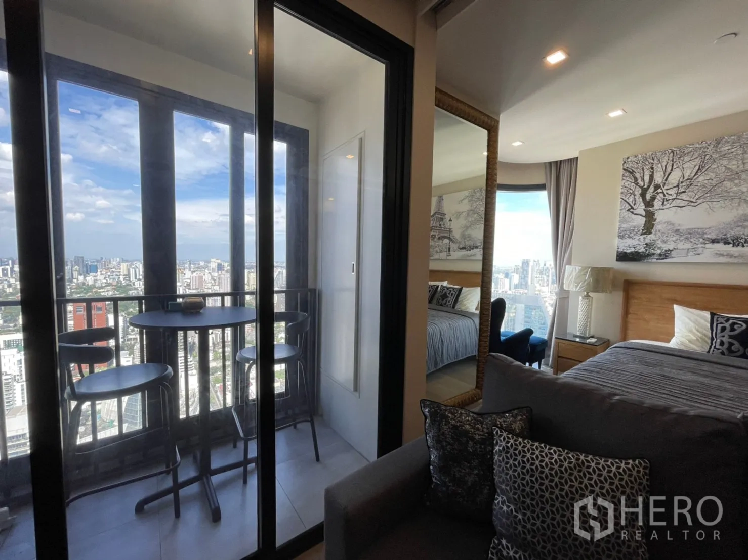 公寓 for rent in Watthana, Bangkok - 推拉门外为阳台座位，内侧可见带大镜子的卧室。
