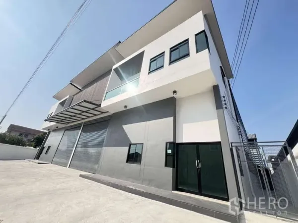 คลังสินค้า ให้เช่าหรือขาย - มุมมองด้านหน้าโกดังพร้อมประตูสำนักงานกระจก กันสาด และประตูรั้วด้านข้าง