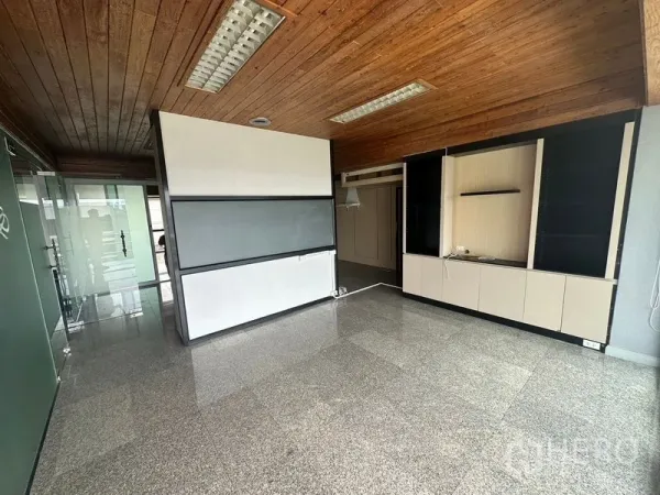 Office Space for rent - Open-plan office interior with wooden ceiling, glass partition and built-in cabinets.