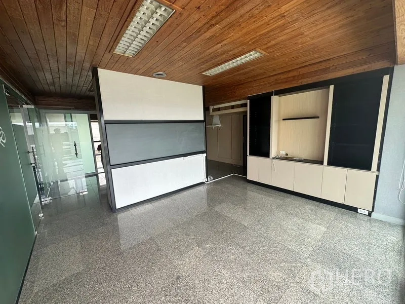 Office Space for rent - Open-plan office interior with wooden ceiling, glass partition and built-in cabinets.