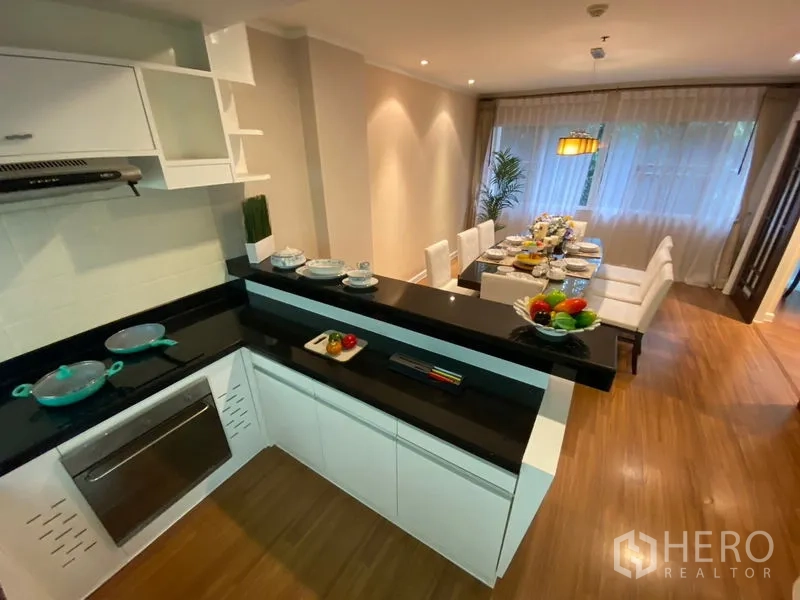 อพาร์ทเมนท์ ให้เช่าในWatthana, Bangkok - ครัวรูปตัว U เคาน์เตอร์หินสีดำ พร้อมบาร์เสิร์ฟหันสู่โซนรับประทานอาหาร