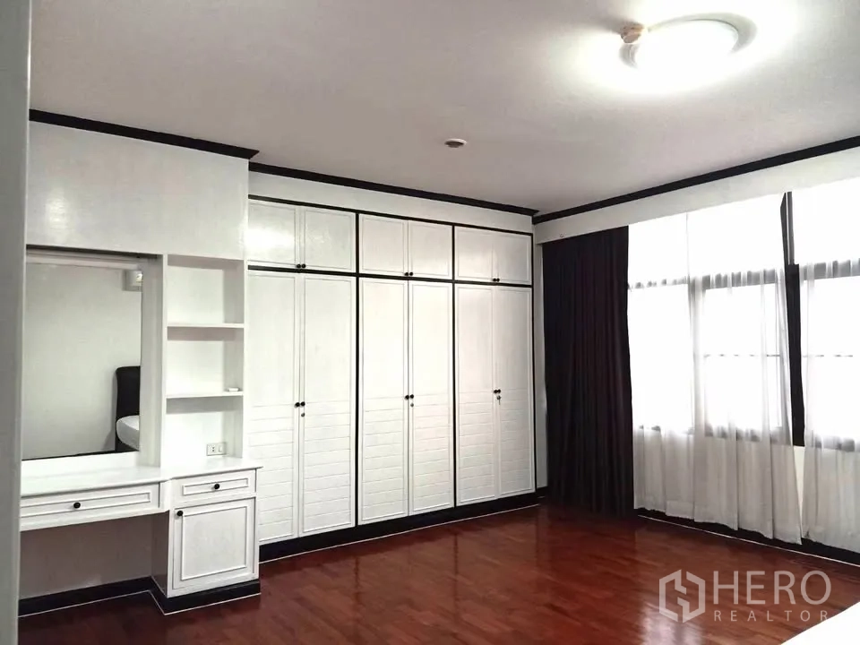 คอนโด for rent in Watthana, Bangkok - มุมห้องนอนหลักมีตู้เสื้อผ้าบิลท์อินเต็มผนัง โต๊ะเครื่องแป้ง และหน้าต่างบานใหญ่