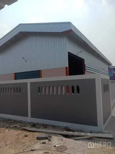 Warehouse for rent in Pathum Thani - Corner view of a new steel-clad warehouse with a solid perimeter wall in Pathum Thani.