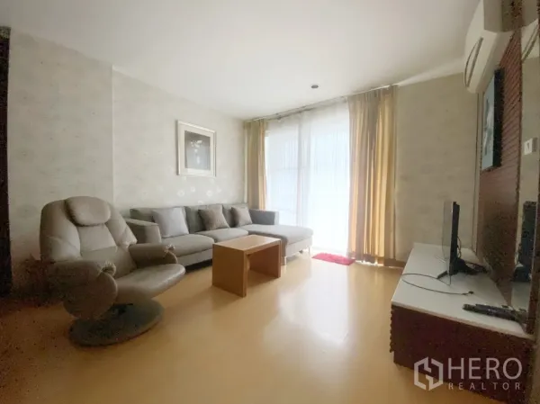 คอนโด ให้เช่าในWatthana, Bangkok - ห้องนั่งเล่นสว่างด้วยหน้าต่างขนาดใหญ่ โซฟาสีเทา เก้าอี้เอน และชั้นทีวี