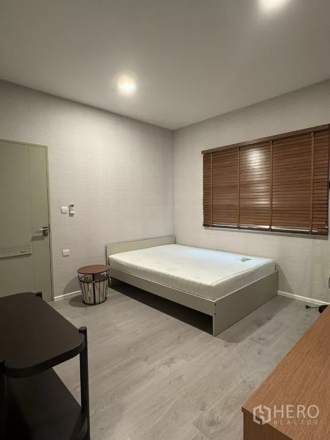 บ้าน ให้เช่าในPrawet, Bangkok - ห้องนอนรับแขกพร้อมมู่ลี่ไม้ เตียง และพื้นลามิเนต.