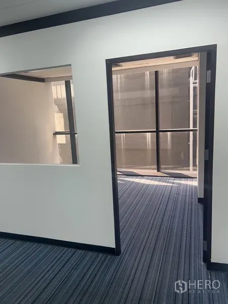 办公空间 出租在Pathum Wan, Bangkok - 通向整面窗房间的门口，为紧凑办公室带来日光。