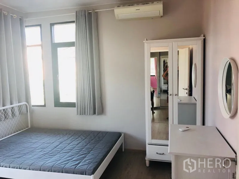 Detached House for rent in Bang Phli, Samut Prakan - Air-conditioned bedroom with bed frame, mirrored wardrobe and big windows with curtains