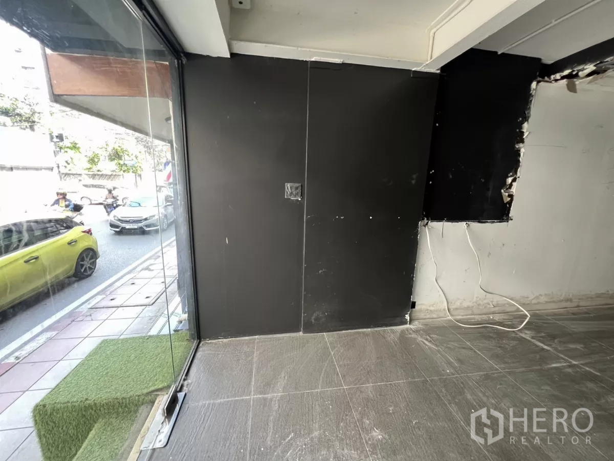 零售空间 出租在Watthana, Bangkok - 店铺转角处的大面积落地玻璃，面向繁忙街道。