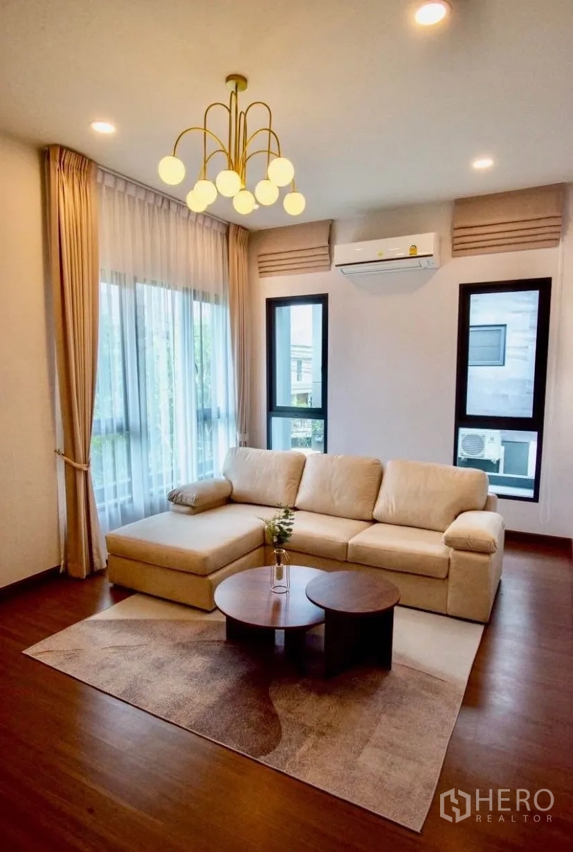 Detached House for rent in Bang Phli, Samut Prakan - Upstairs family room featuring beige sofa, modern chandelier and wood flooring.