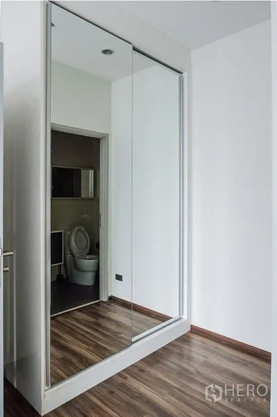 公寓 出租在Khlong Toei, Bangkok - 走廊处的通顶镜面衣柜，映射木质地板。