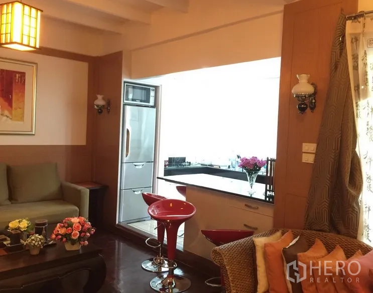 联排别墅 出租在Watthana, Bangkok - 开放式起居区，早餐吧台与红色高脚凳，通往明亮厨房。