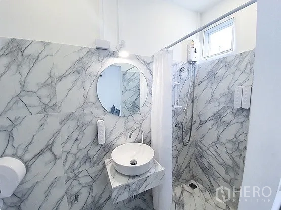 Retail Space for rent in Khlong Toei, Bangkok - Bathroom with marble-pattern tiles, round mirror, vanity and walk-in shower.
