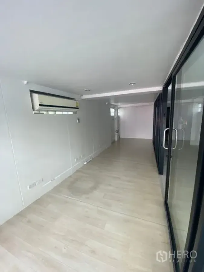 พื้นที่ขายปลีก ให้เช่าในWatthana, Bangkok - ภายในร้านทรงลึก พื้นไม้ลามิเนต ผนังสีขาว ไฟดาวน์ไลท์ ประตูกระจกบานเลื่อน และแอร์แขวนผนัง