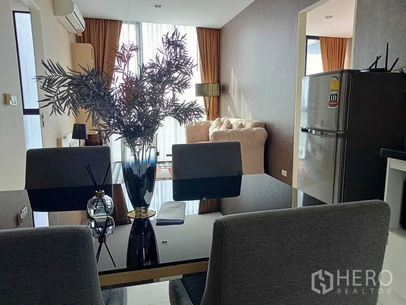 คอนโด ให้เช่าในWatthana, Bangkok - โซนทานอาหารมีแจกันบนโต๊ะกระจก หันหน้าไปยังพื้นที่นั่งเล่นและหน้าต่างบานใหญ่.