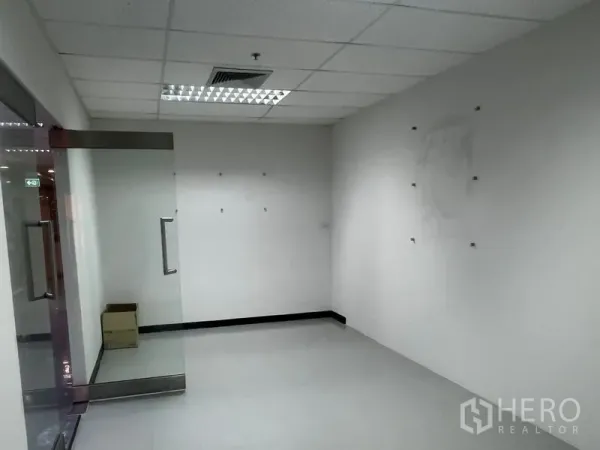 办公空间 出租 - 小型接待或会议室，玻璃门与瓷砖地面，吊顶照明。