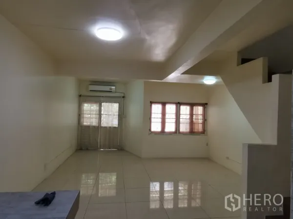 ทาวน์เฮาส์ ให้เช่าในKhlong Toei, Bangkok - ห้องนั่งเล่นกว้าง พร้อมหน้าต่างบานใหญ่ เครื่องปรับอากาศ และทางขึ้นบันได