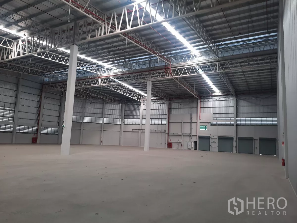 Factory for rent in Bang Lamung, Chon Buri - Warehouse interior showing roller shutters and loading docks.
