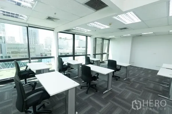 办公空间 出租 - 明亮的开放式办公区，白色工位、人体工学椅与大窗，俯瞰城市天际线。