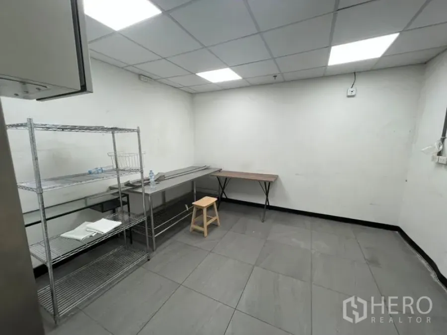 零售空间 出租在Watthana, Bangkok - 干净的后勤备餐区，瓷砖地面、吊顶照明，配不锈钢置物架与工作台，位于素坤逸零售铺面内。