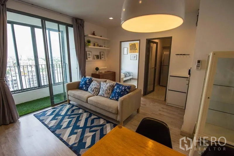 คอนโด ให้เช่าในPhra Khanong, Bangkok - ห้องนั่งเล่นหันสู่ระเบียง ประตูกระจกบานเลื่อนและหญ้าเทียม