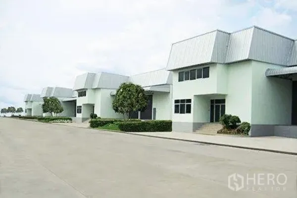 Warehouse for rent in Bang Phli, Samut Prakan - Row of clean warehouse units along a wide truck-friendly internal road with landscaping.