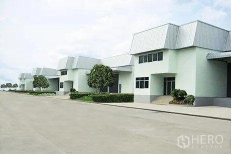Warehouse for rent in Bang Phli, Samut Prakan - Row of clean warehouse units along a wide truck-friendly internal road with landscaping.