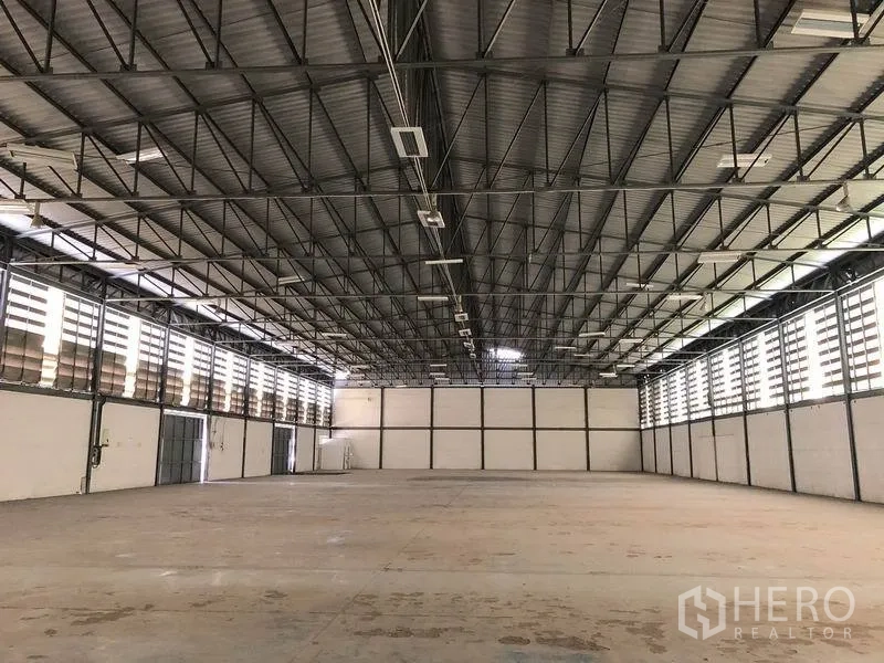 货栈 出租在Khlong Luang, Pathum Thani - 开阔的仓库地面与高金属屋顶，两侧百叶窗采光通风，混凝土地坪。