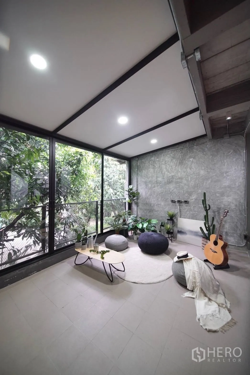 ทาวน์เฮาส์ ให้เช่าในWatthana, Bangkok - ห้องซันรูมกระจกเต็มบาน ผนังคอนกรีตขัดมัน พร้อมต้นไม้และพัฟนั่ง
